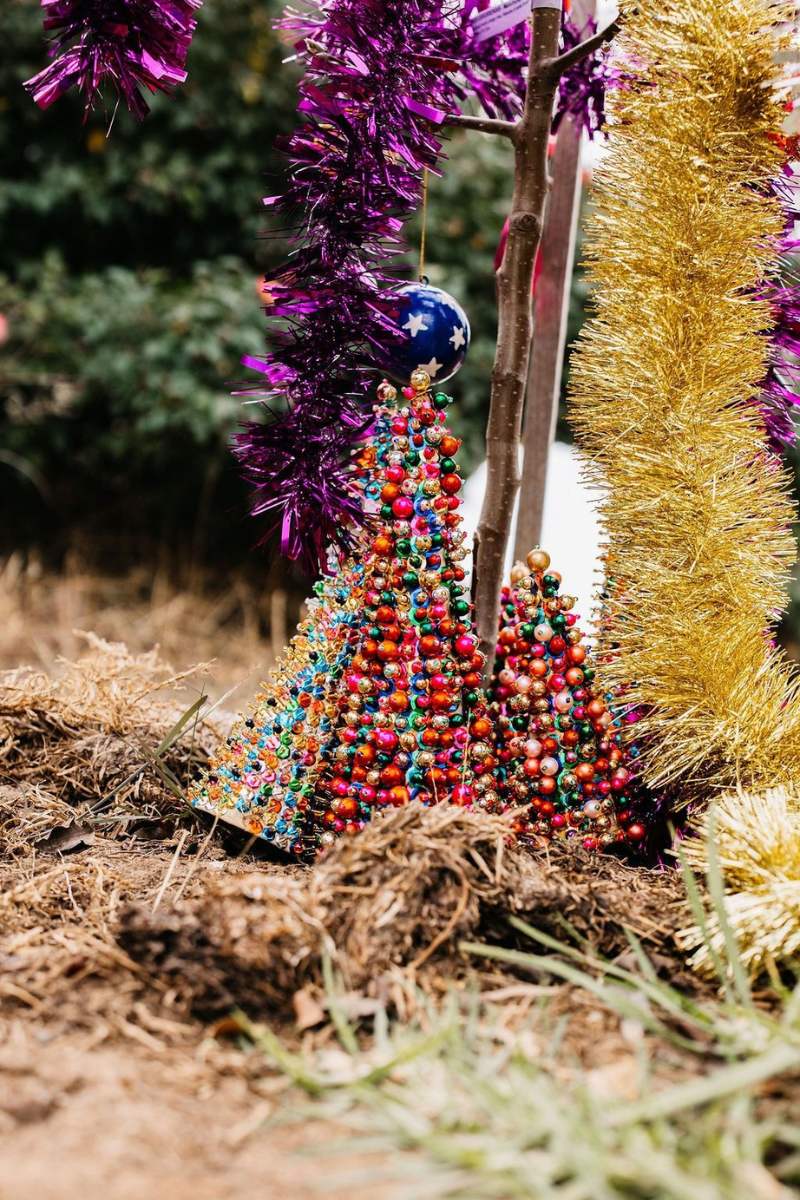 Colorful beaded Christmas tree with tinsel and purple decorations on a natural background