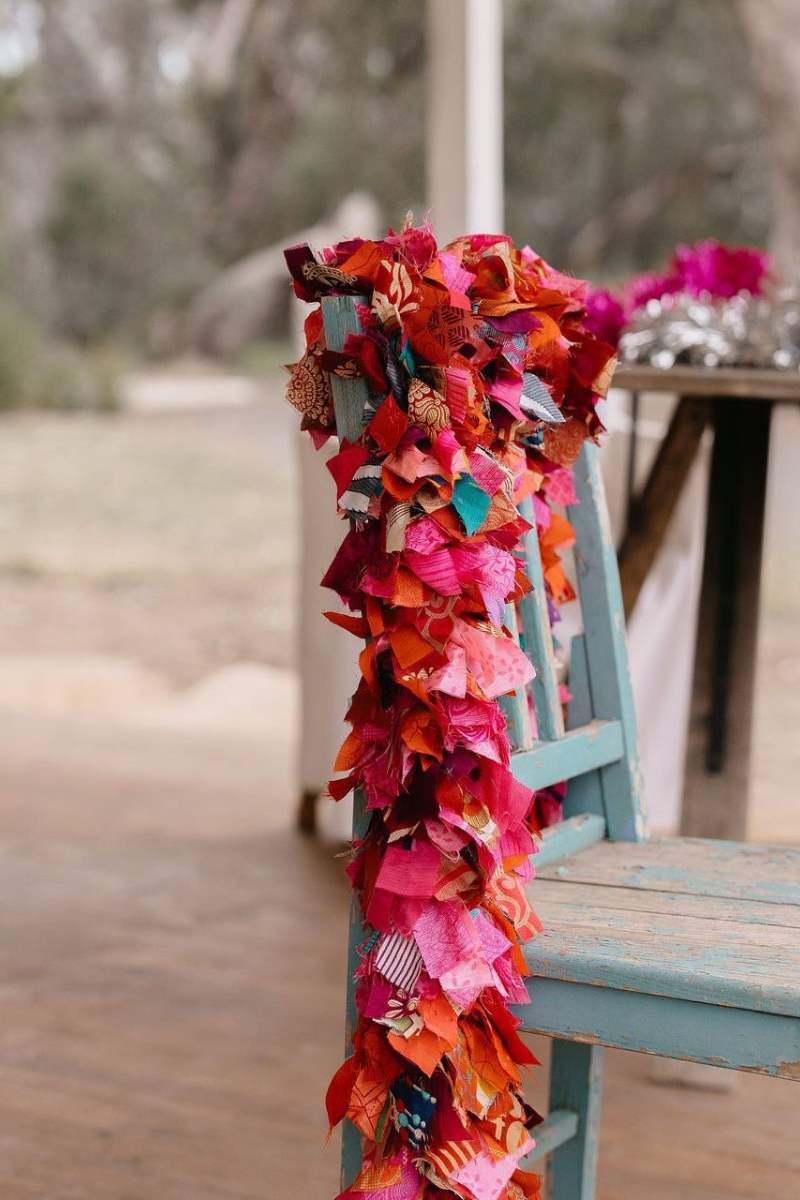 Colorful fabric rags draped over a chair outdoors - christmas garland by Mink and Me