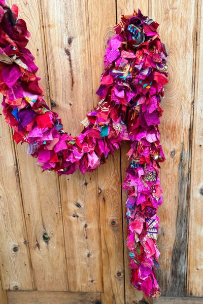 Colorful fabric against a wooden background - Colorful fabric rags draped over a chair outdoors - christmas garland by Mink and Me