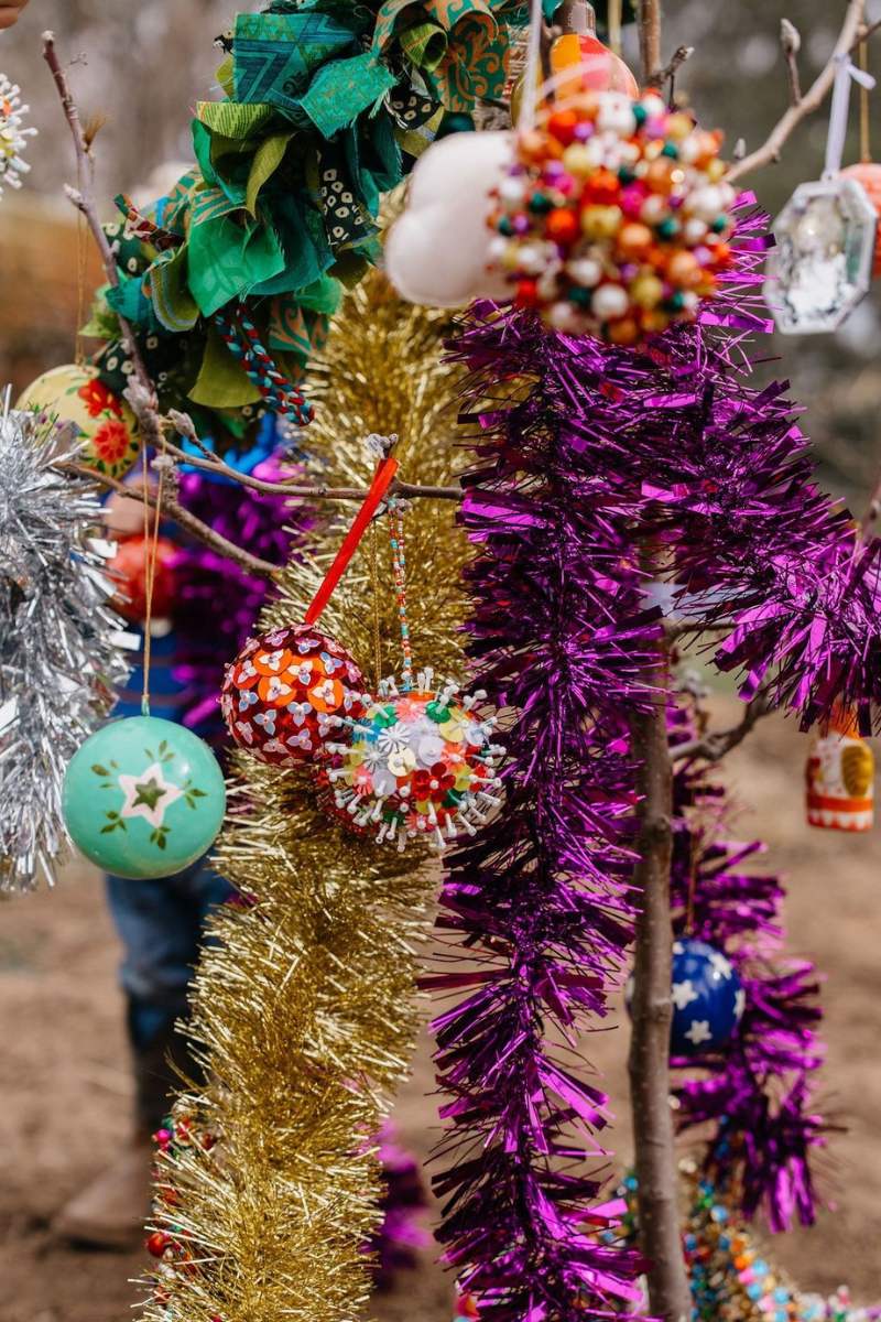 Decorative tinsel and ornaments on a tree with a blurred background