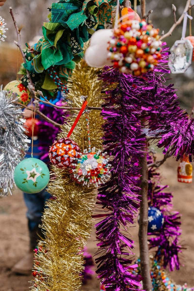 Decorative tinsel and ornaments on a tree with a blurred background