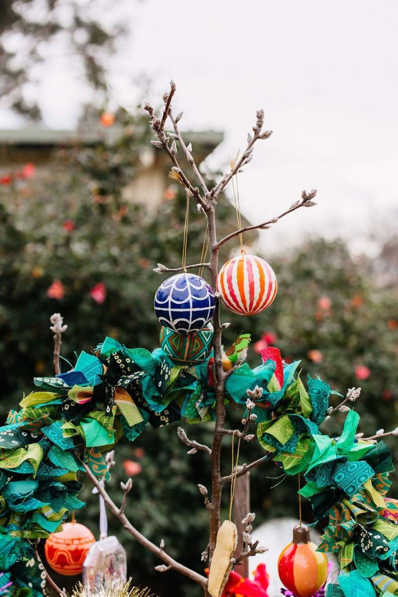 Decorative treewith colorful ornaments on a branch against a blurred natural background