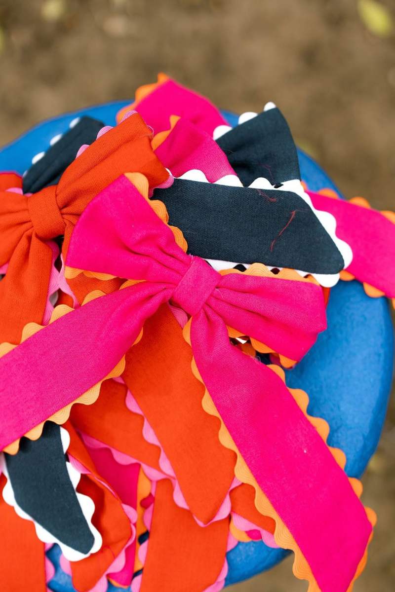 Colorful fabric dragon with pink bows on a blurred natural background