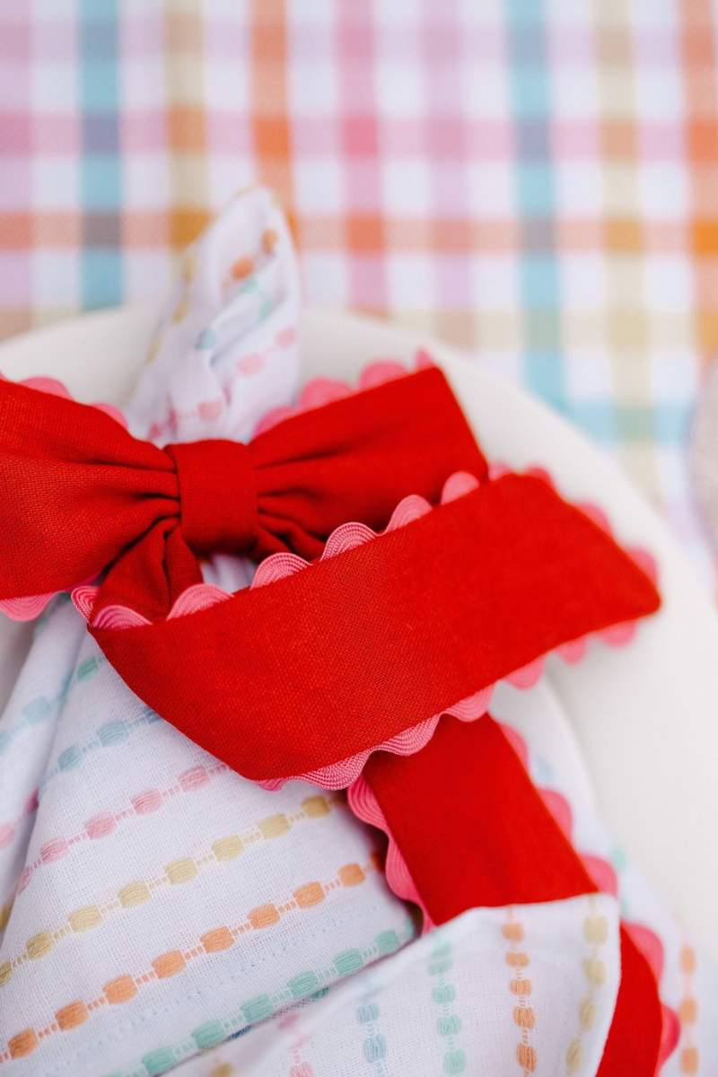 Polka dot fabric with a red bow on a colorful plaid background