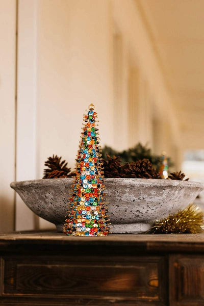 Colorful decorative Christmas tree on a rustic surface with a blurred background