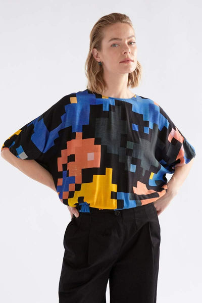 Person wearing a colourful pixel-patterned ELK top on a white background