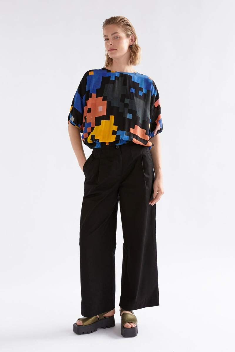 Person wearing a colourful pixel-patterned ELK top on a white background