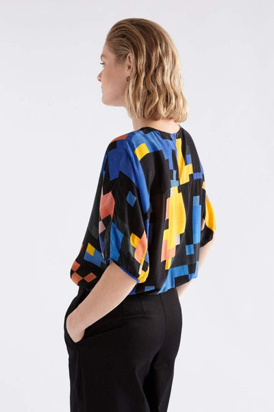 Person wearing a colourful pixel-patterned ELK top on a white background