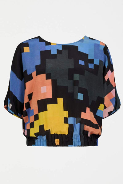 Person wearing a colourful pixel-patterned ELK top on a white background