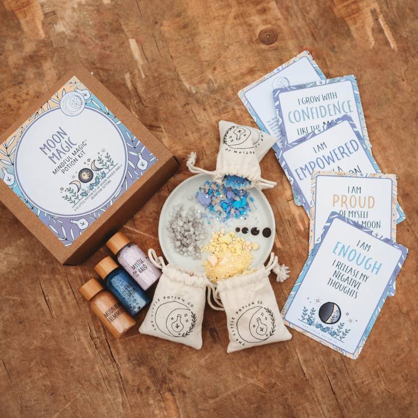 Moon magic kit with cards, bottles, and pouches on a wooden surface