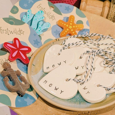 Newy Heart Tag by Caroline C with small ribbon. Made from ceramic with NEWY printed on the edge.