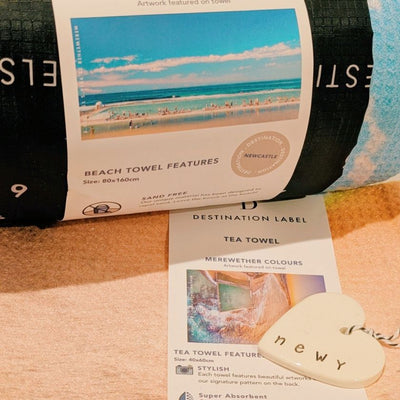 Newy Heart Tag by Caroline C with small ribbon. Made from ceramic with NEWY printed on the edge.