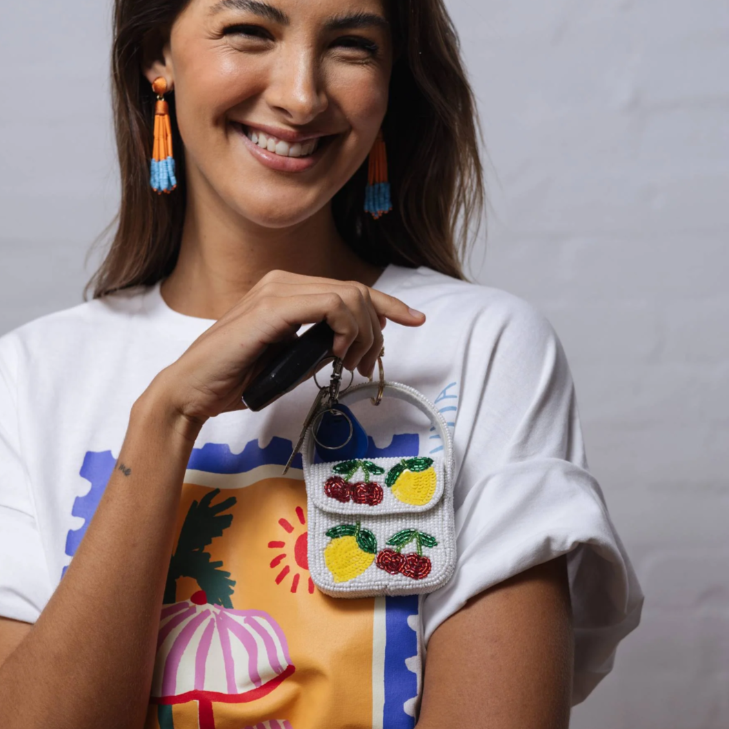 Woman holding a colorful beaded handbag with a plain background by Zoda 