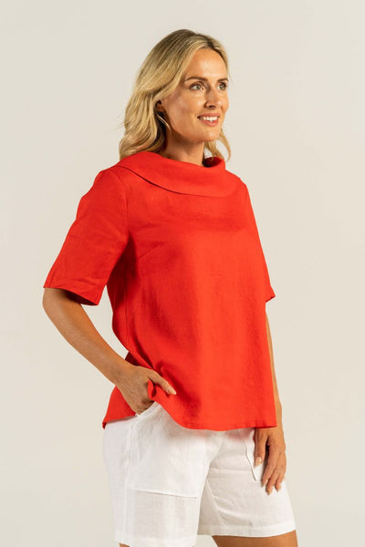 A woman exudes confidence in a vibrant red cowl neck top with medium sleeves and button back detailing.
