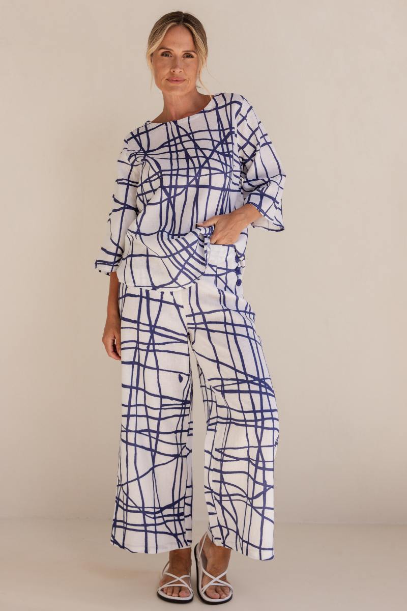 Woman wearing a blue and white patterned outfit on a beige background by See Saw | See Saw Stockist at Zebra Finch marketown in Newcastle, NSW