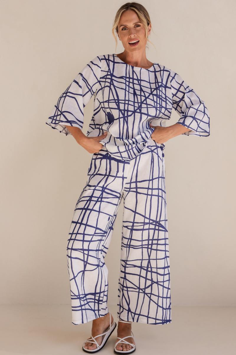 Woman wearing a blue and white patterned outfit on a beige background by See Saw | See Saw Stockist at Zebra Finch marketown in Newcastle, NSW