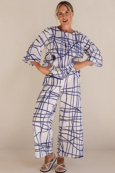 Woman wearing a blue and white patterned outfit on a beige background by See Saw | See Saw Stockist at Zebra Finch marketown in Newcastle, NSW