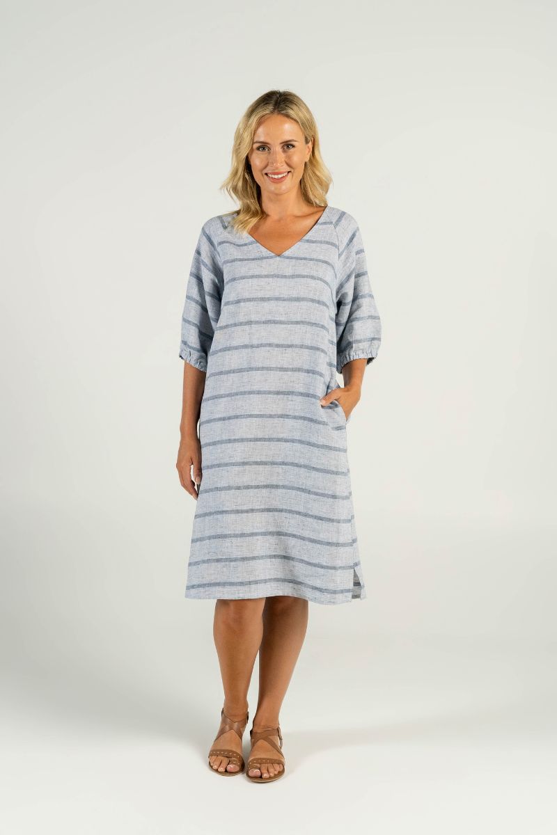 A confident model showcases effortless summer style in the V-Neck Linen Dress with classic blue and white stripes. The flattering V-neck design and breathable linen fabric create a cool and comfortable look, perfect for any occasion.