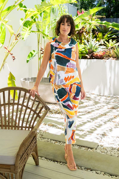 Woman in a colorful outfit standing in a garden setting