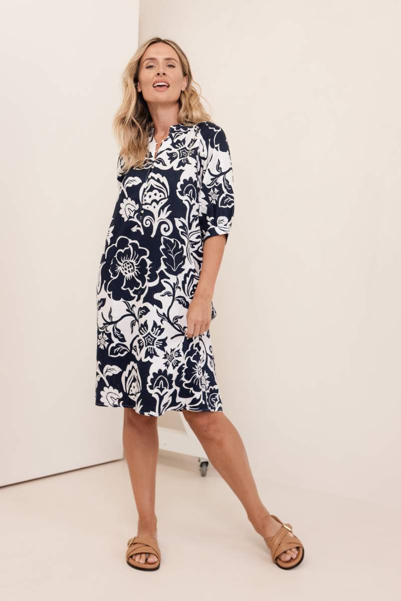Woman wearing a navy floral dress on a white background