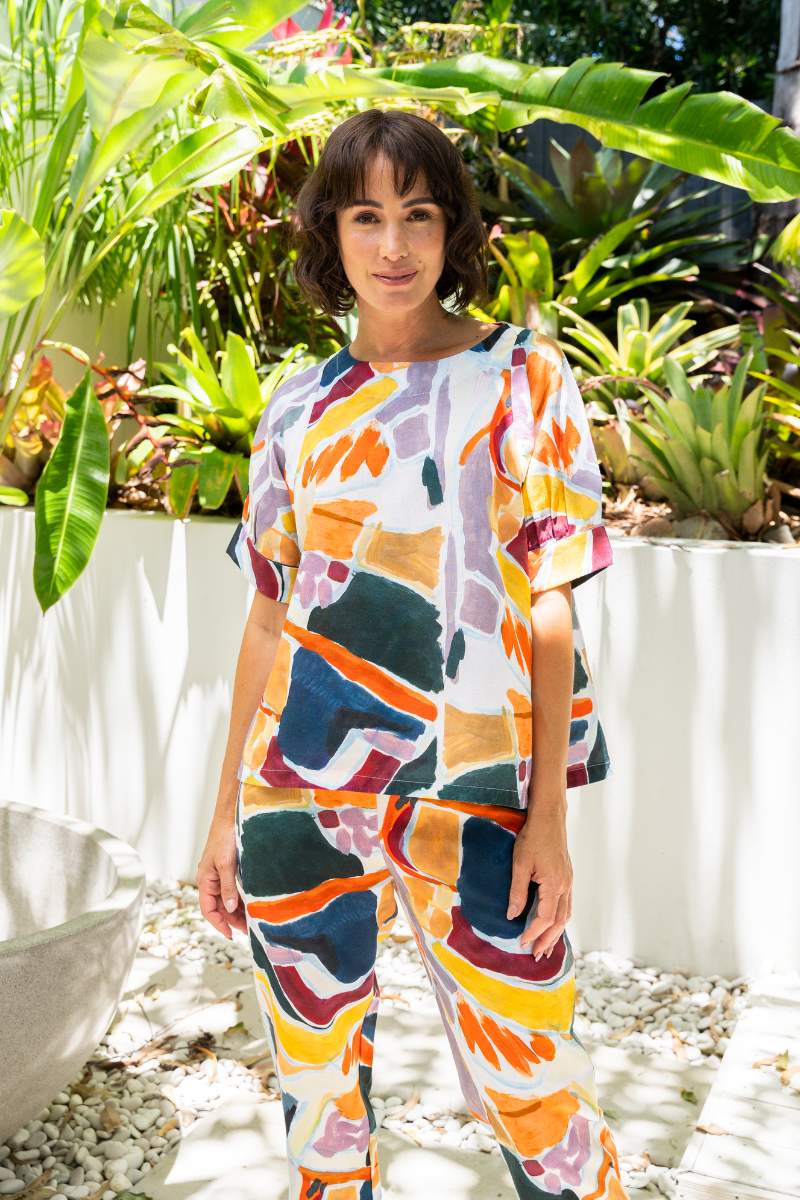 Woman wearing a colourful outfit standing in a garden setting