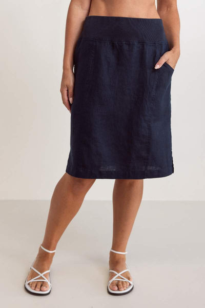 Person wearing a navy blue skirt on a plain background
