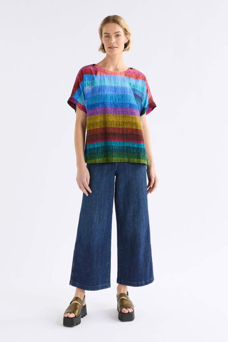 Woman wearing a colourful ELK striped shirt against a white background