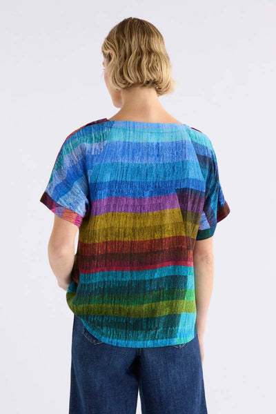 Woman wearing a colourful ELK striped shirt against a white background