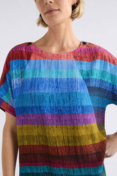 Woman wearing a colourful ELK striped shirt against a white background