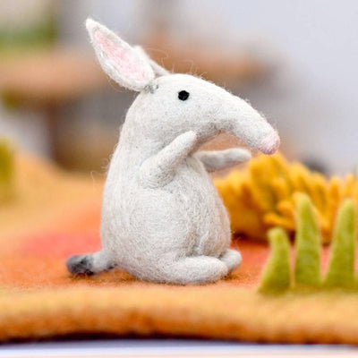 White plush bilby toy on a colorful fabric background