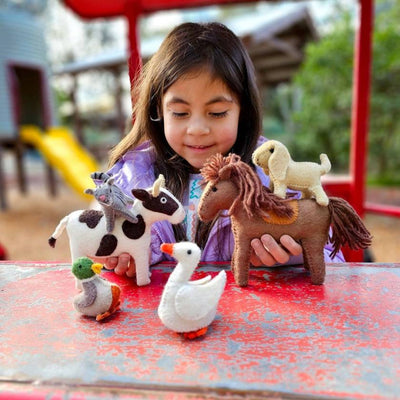 Child playing with toy animals on a playground table