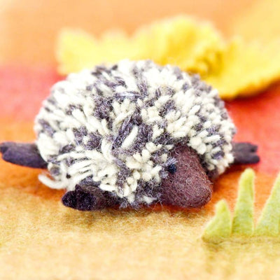 Plush toy echidna on a textured orange surface