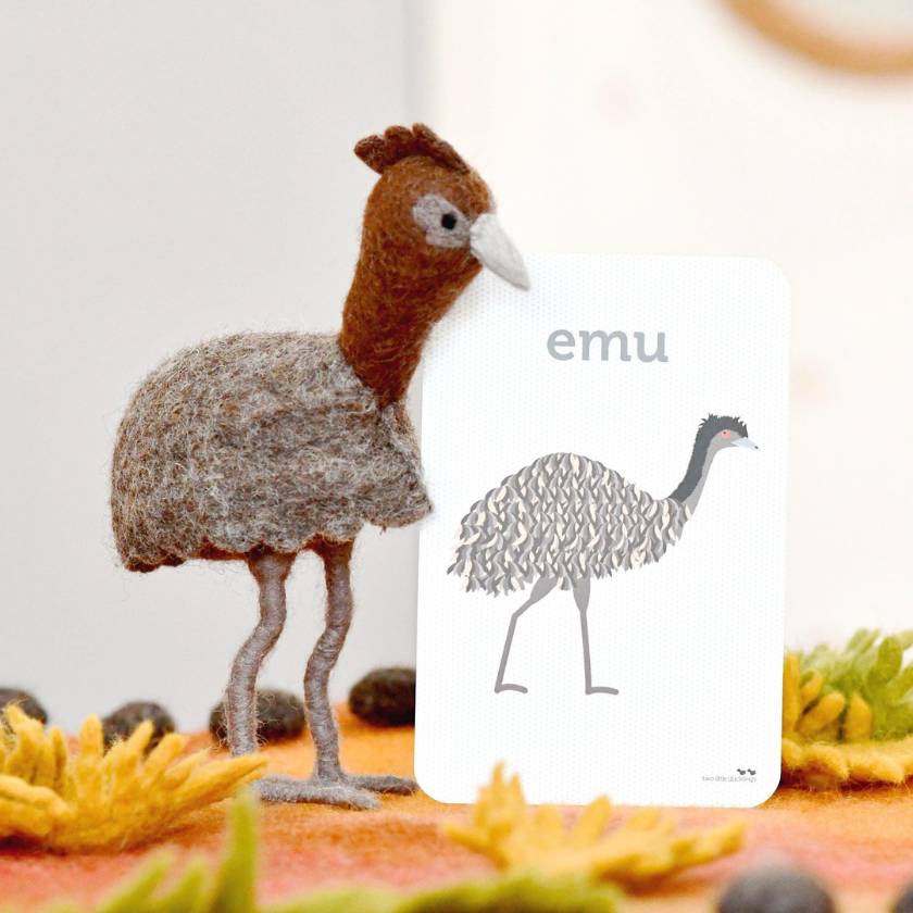 Model of an emu with a white card displaying 'emu' text on a colorful background