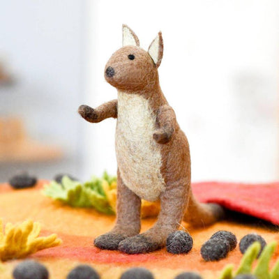 Felted animal figurine of a kangaroo on a textured surface with blurred background