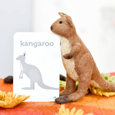 Plush kangaroo toy on a colorful surface with a card labeled 'kangaroo'.
