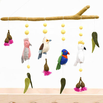 Colorful bird mobile hanging from a branch with a white background