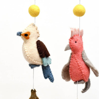 Knitted bird and squirrel mobile with yellow balls on a white background
