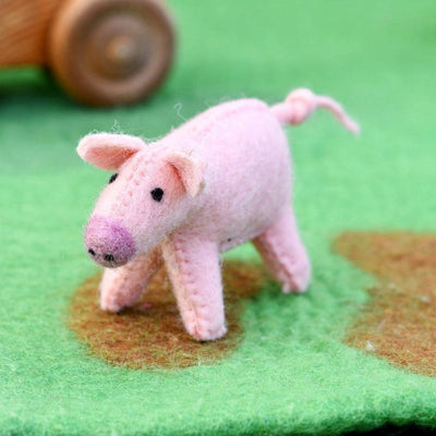 Pink pig toy on a green fabric background