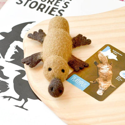 Plush toy platypus on a wooden surface with a card labeled 'Platypus' in the background.