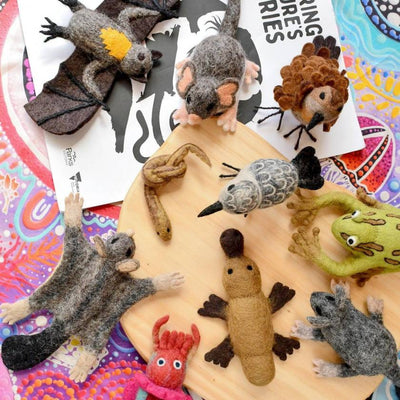 Collection of felt animal toys on a colorful surface