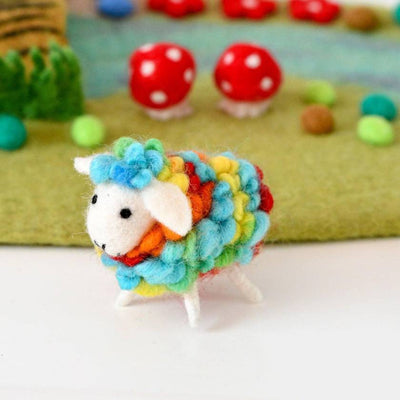 Colorful felt sheep toy with a garden background featuring mushrooms and plants.