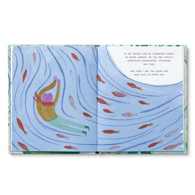Open book with a colorful illustration of a person swimming with fish in an ocean-like setting.