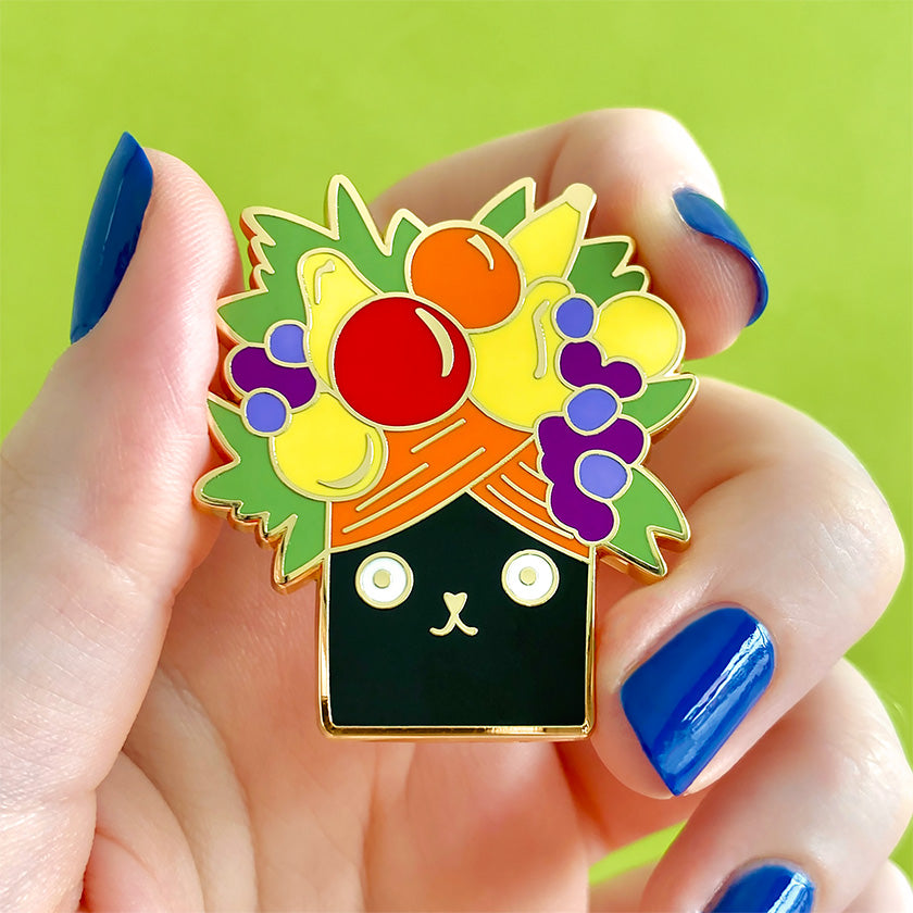 Catmen Miranda Enamel pin by Erstwilder from their 2023 Terry Runyan collection, held in hand