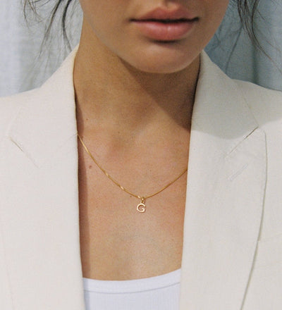 Model wearing Kirstin Ash necklace with G initial charm