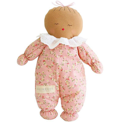 Awake asleep doll with darker skin and pink floral design on body with eyes shut