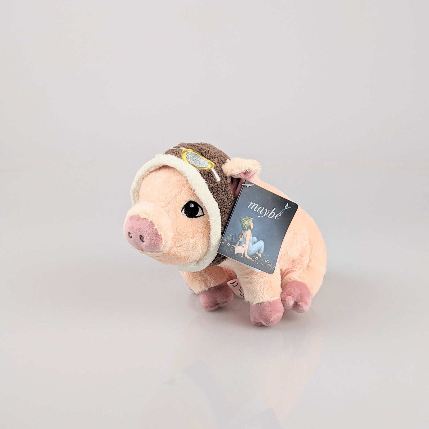 Cute, pink pig wearing aviator goggles on its head.