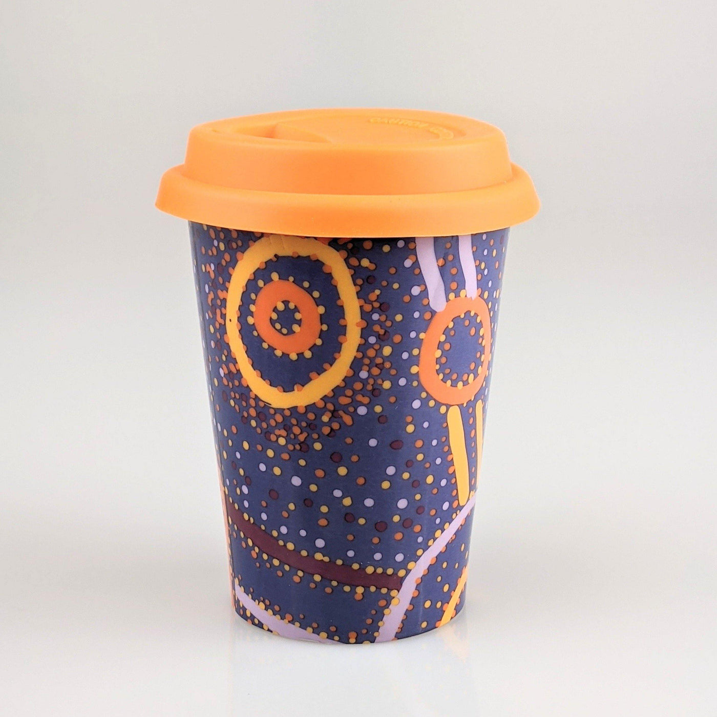 Coffee cup with orange and navy indigenous design printed on it.