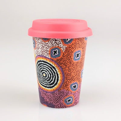 Coffee cup with hot pink, orange white and blue indigenous design printed on it.
