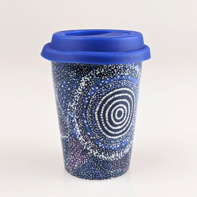 Coffee cup with dark blue with white dots indigenous design printed on it.