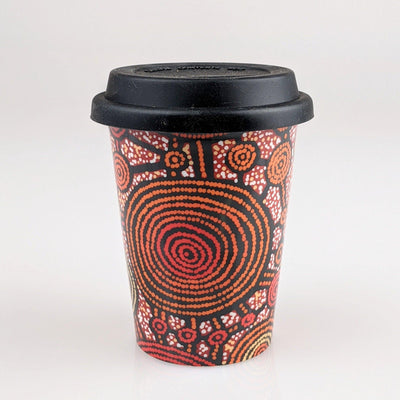 Coffee cup with red and black indigenous design printed on it.
